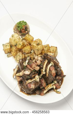 Stewed Beef Short Ribs And Mushrooms In Gravy With Roast Potatoes On White Background