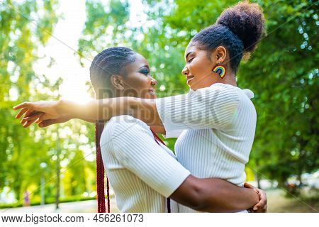 Brazilian Lesbian Couple In White Dress Spending Time Together Celebrating Engagement In Summer Park