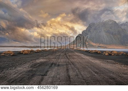 Tiretracks On Beach Against Stokksnes Cape And Vestrahorn Mountain At Sunset