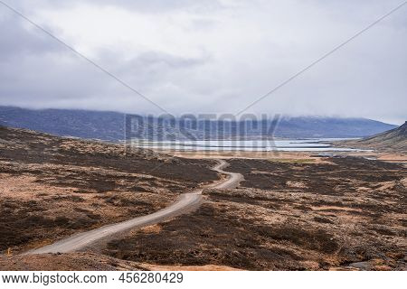 Idyllic View Of Road Amidst Dramatic Landscape At Eastfjords Against Cloudy Sky