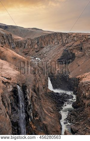 Beautiful Litlanesfoss Waterfall In Eastfjords Against Cloudy Sky During Sunset