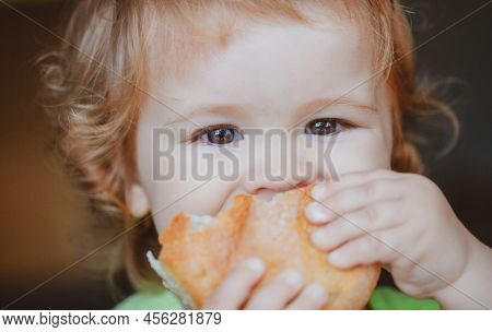 Baby Eating Bun Bread. Close Up Face. Cute Toddler Child Eating Sandwich, Self Feeding Concept.