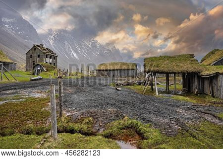 Tiretracks By Traditional Houses In Viking Village Against Cloudy Sky At Sunset