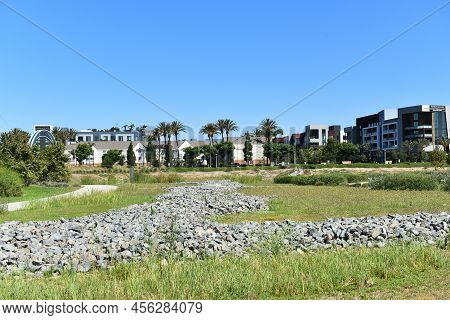TUSTIN, CALIFORNIA - 12 JUN 2022: Tustin Legacy Park looking towards Redhill Avenue with Apartments and businesses.