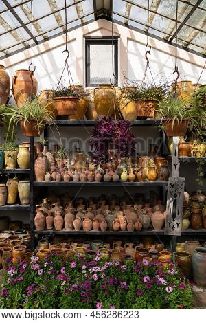 Many Unique Handmade Colorful Clay Jugs And Vases Of Various Shapes On Shelf, Blooming Flowers And H