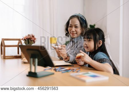 Smiling Senior Grandma And Cute Little Kid Granddaughter Watching Cartoons On Laptop Together, Happy