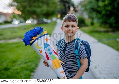 Little Kid Boy With School Satchel On First Day Of School, Holding School Cone With Gifts