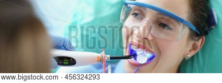 Portrait Of Woman Client In Stomatology Clinic Get Teeth Whitening With Special Equipment. Patient W