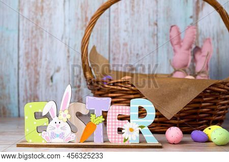 Easter Wooden Sign Stads Against Easter Basket With Eggs And Toy Bannies.happy Easter Banner