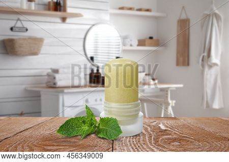 Natural Crystal Alum Deodorant And Mint Leaves On Wooden Table In Bathroom