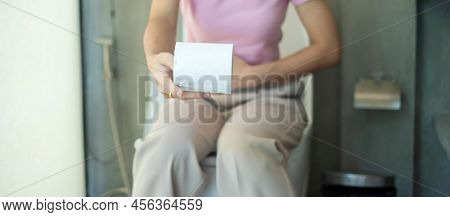 Woman Holding Toilet Paper Roll During Sit On Toilet Bowl. Diarrhea, Constipated Period, Infection, 