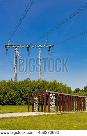 Mast Of Power Lines Under Which There Is A Wooden Crossing. High Quality Photo