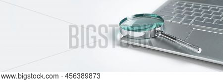 Magnifying Glass And Laptop Pc On Background Banner With Copy Space For Text. High Quality Photo