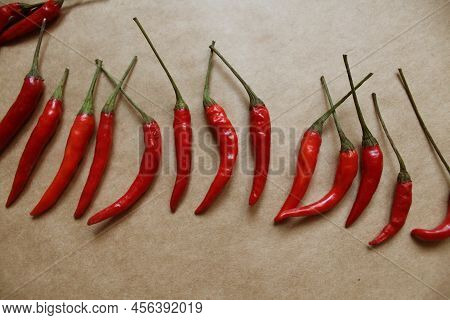 Chili Pepper On Craft Paper Background. Top View Photo Of Red Peppers On Table