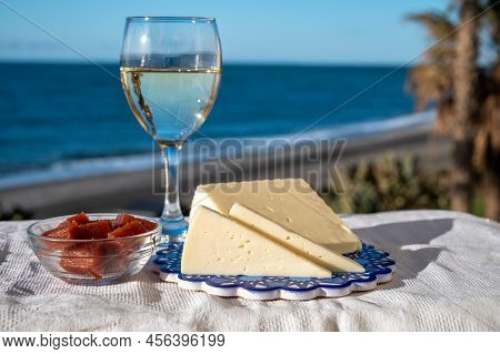Spanish Hard Goat Cheese Served Outdoor With Membrillo Jam And Glass Of White Wine With Blue Sea On