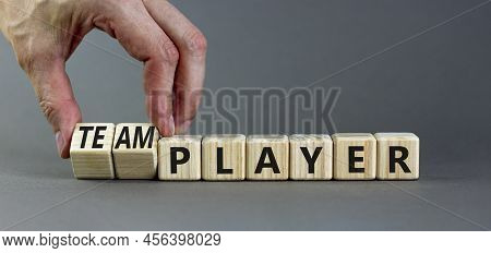 Player Or Teamplayer Symbol. Businessman Turns Wooden Cubes And Changes Concept Words Player To Team