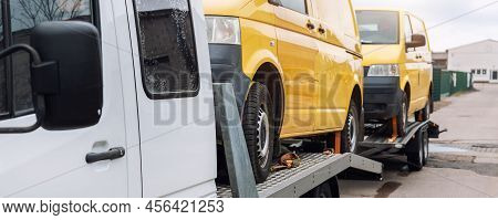 White Small Cargo Truck Car Carrier Loaded With Two Yellow Van Minibus On Flatbed Platform And Semi 