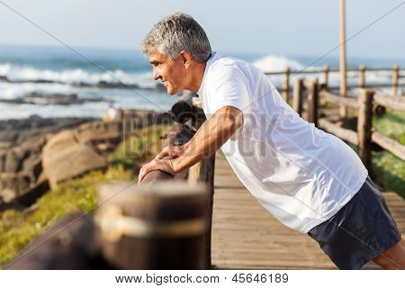 ajustement senior homme exerçant à la plage le matin
