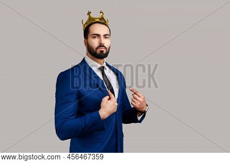 Portrait Of Self Confident Bearded Man In Golden Crown Pointing At Herself With Finger, Superior Pri