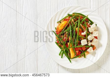 Fasolakia Lathera, Green Beans, Onion And Potatoes Stewed In Tomato, Herbs And Olive Oil On White Pl