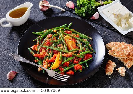 Fasolakia Lathera, Green Beans, Onion And Potatoes Stewed In Tomato, Herbs And Olive Oil On Black Pl