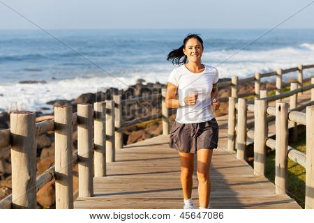 ajustement milieu âge femme jogging sur la plage le matin