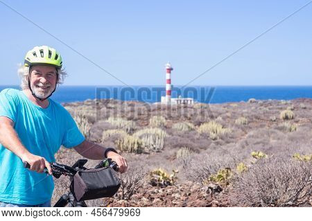 Happy White-haired Active Seniorman Cycling Off Road With Electric Bicycle At Sea, Elderly Caucasian