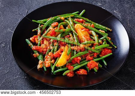Fasolakia Lathera, Green Beans, Onion And Potatoes Stewed In Tomato, Herbs And Olive Oil On Black Pl
