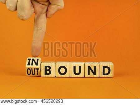 Inbound Or Outbound Symbol. Businessman Turns Wooden Cubes And Changes The Concept Word Outbound To 