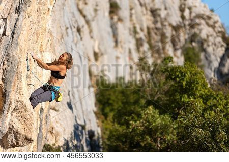 A Strong Girl Climbs A Rock At A High Altitude, A Climber Trains On The Rocks, Training Strength And