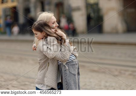Girl Hugging Her Nother With A Flag Of Ukraine On A Cheek