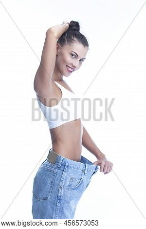 Positive Smling Good Fit Sexy Slim Caucasian Woman Posing In Lose Oversized Jeans Demonstrating Diet