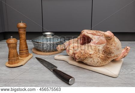 Raw Homemade Chicken Meat On A Wooden Gray Flooring With A Knife And A Frying Pan. The Carcass Of A 