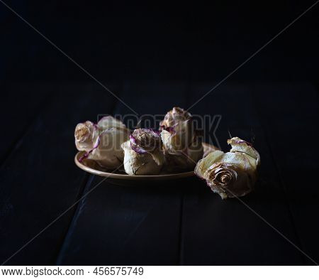 Dead Or Withered Roses Flower Heads On Black Wooden Table With Copy Space. Dried Flowers On Black Ba