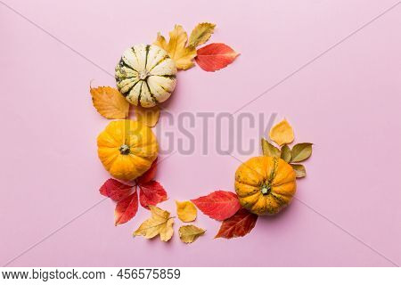 Autumn Composition Pumpkins With Fall Leaves Over Coloredbackground. Top View With Copy Space.