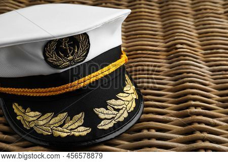 Peaked Cap With Accessories On Wicker Surface, Closeup. Space For Text