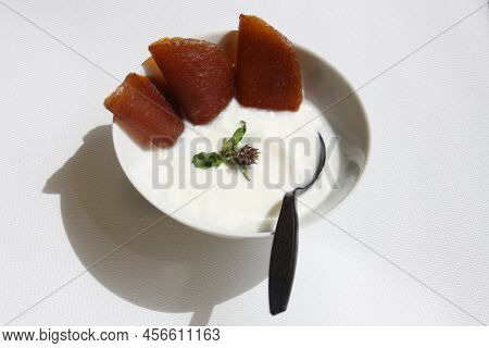 White Unflavored Yoghurt With Natural Color Stirred Mango, No Sugar Added, Garnished With Basil.
