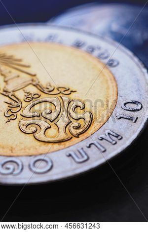 Translation: 10 Baht Thailand. Thai Coin Of 10 Baht Lie On Dark Surface Closeup. News About Money. T