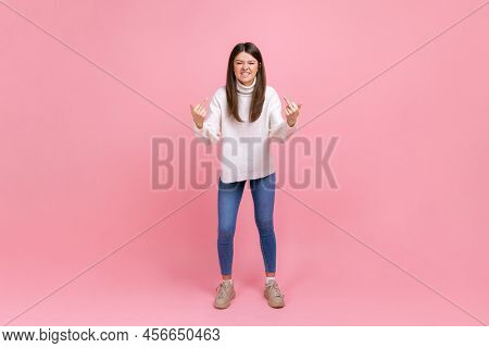 Full Length Portrait Of Aggressive Girl Standing And Shows Fuck Sign With Both Hands Into The Camera