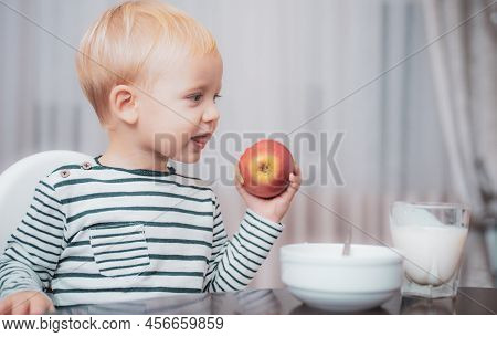 Child Eat Porridge. Kid Cute Boy Blue Eyes Sit At Table With Plate And Food. Healthy Food. Boy Cute 