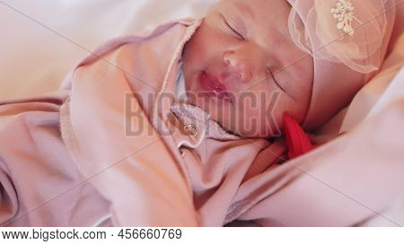 Newborn Baby Girl Sleeping With Pacifier. Baby Sleeps With A Pacifier In A Hat In Bed. Happy Family 