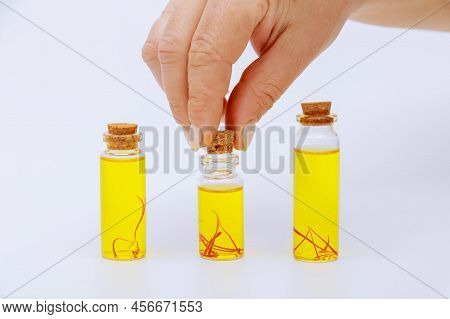 The Girl Puts A Wooden Lid On The Jar. Saffron Drink In Small Jars On A White Background.