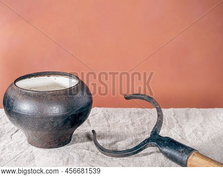 Vintage rural cast-iron pot with a hand tool to move it