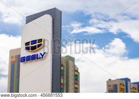 Krasnoyarsk, Russia - June 19, 2022: Geely Dealership Logo Against Cloudy Sky Background. Geely Auto