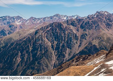 Rocky Snow-capped Mountains Under The Sun And Blue Sky