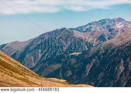 Rocky Snow-capped Mountains Under The Sun And Blue Sky
