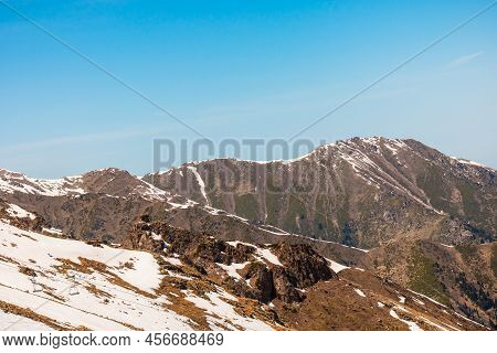 Rocky Snow-capped Mountains Under The Sun And Blue Sky