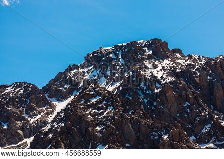 Rocky Snow-capped Mountains Under The Sun And Blue Sky