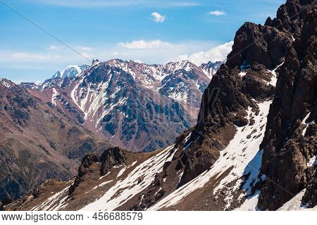 Rocky Snow-capped Mountains Under The Sun And Blue Sky