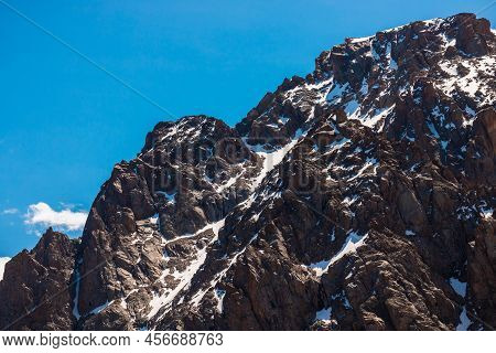 Rocky Snow-capped Mountains Under The Sun And Blue Sky